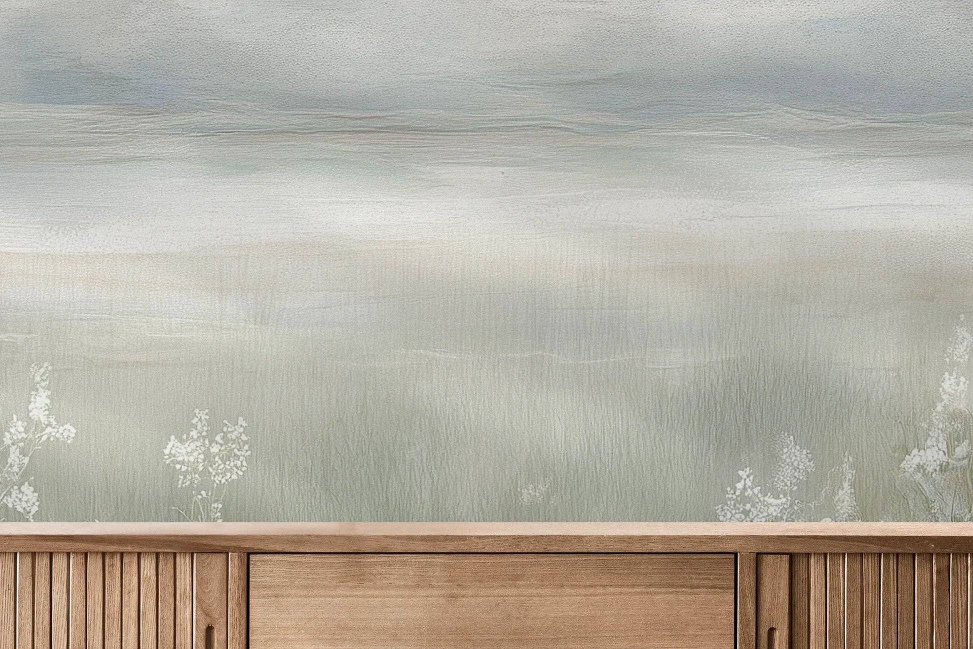 Fototapeta MISTY BLOOM FIELDS - tapeta z mglistą łąką i dzikimi kwiatami pokazana w aranżacji wnętrza z akcentem na ścianie.