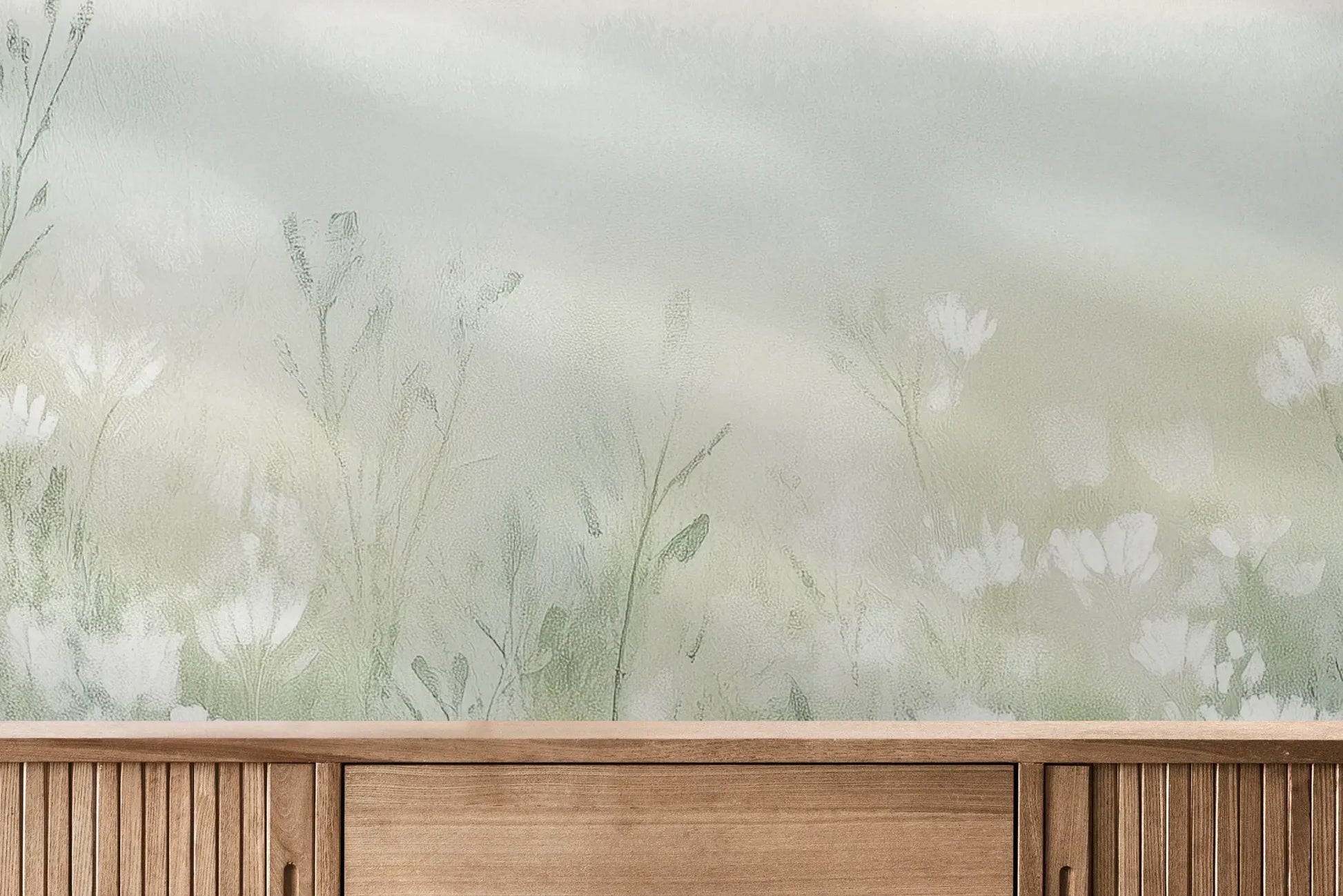 Fototapeta WINTER'S BLOOM - tapeta z mglistą łąką w pastelach pokazana w aranżacji wnętrza z akcentem na ścianie.