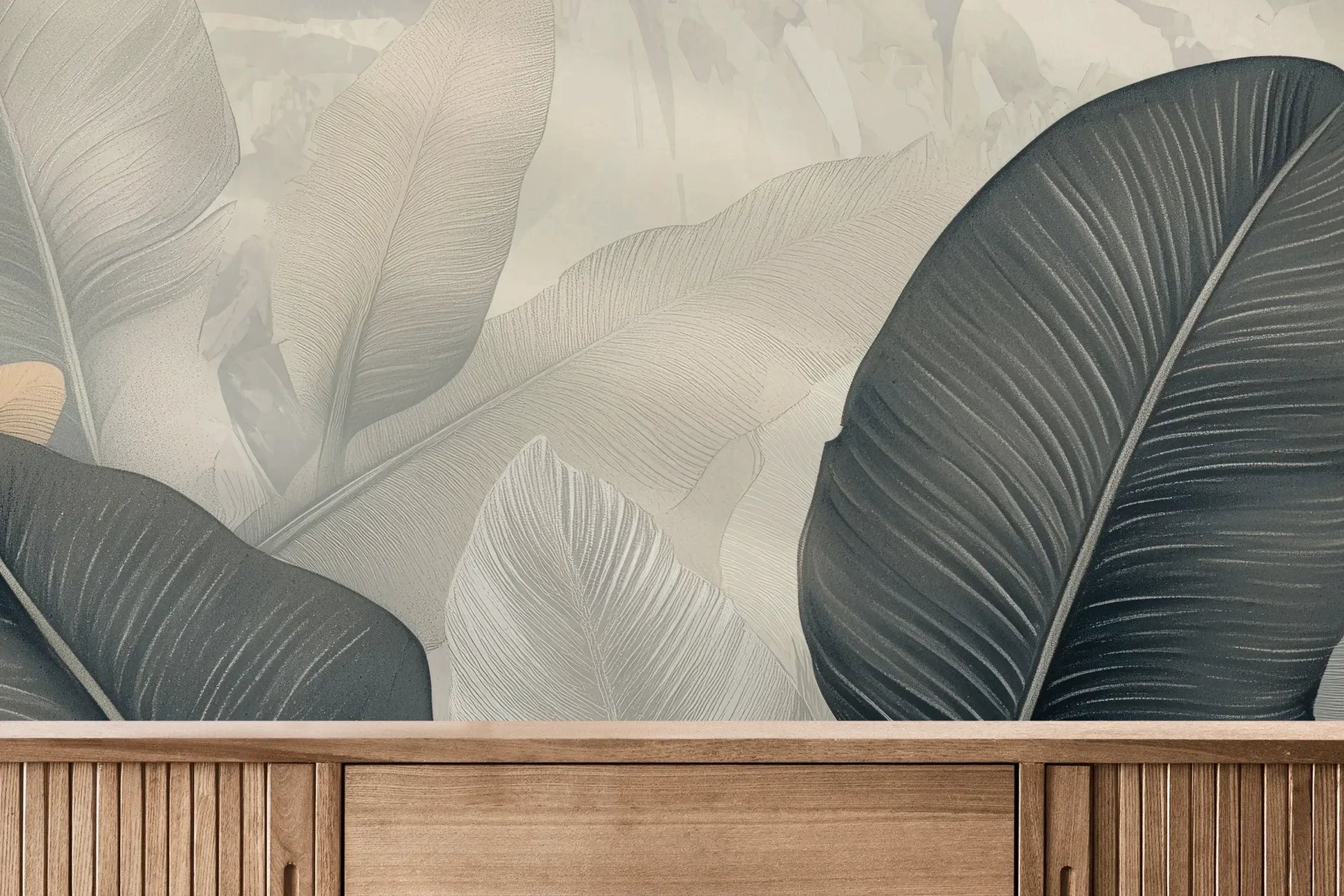 Fototapeta FEATHER SYMPHONY - tapeta z tropikalnymi liśćmi w stonowanych szarościach pokazana w aranżacji wnętrza z akcentem na ścianie.