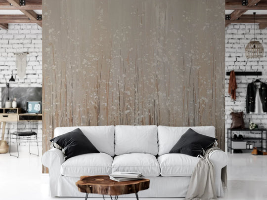 Wzór fototapety GOLDEN WHISPERS - tapeta z delikatnymi źdźbłami traw w beżowej tonacji pokazanej w aranżacji salonu.