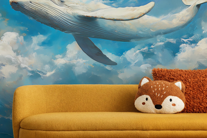 BLUE YONDER aus der Nähe: Kehlfurchen und dunkle Flosse des Wals vor Wolken über senffarbenem Sofa mit Kissen in Fuchsform