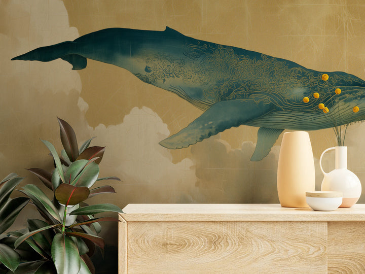 FLOATING WORLD de cerca: cola y tronco de la ballena con ornamento dorado de espirales sobre una cómoda clara con jarrones