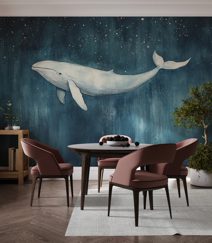 INDIGO NOCTURNE en toda la pared de un comedor: la ballena blanca entera sobre un cielo azul noche con estrellas, encima de una mesa redonda con sillas
