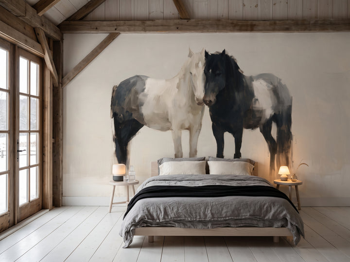KINDRED PAIR en una ambientación de dormitorio: pareja de caballos en toda la pared tras una cama baja con ropa de cama gris y manta negra