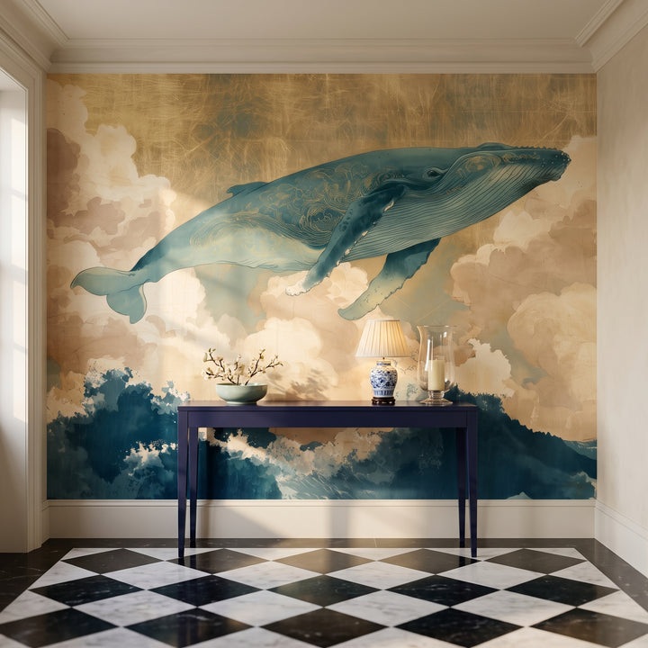 KUJIRA RISING en una ambientación de vestíbulo: ballena entera con ornamento dorado sobre una consola azul marino con lámpara baja, bol y candelero de cristal
