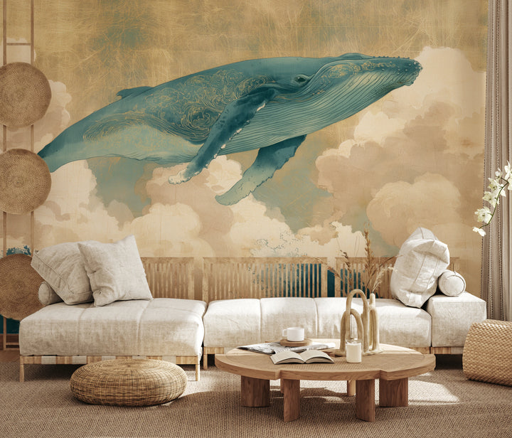 KUJIRA RISING auf der ganzen Wand eines Wohnzimmers: türkisfarbener Wal und cremefarbene Wolken über niedrigem Sofa, Wellen hinter der Lehne