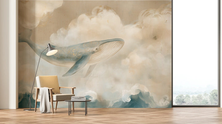 LINEN WHALE auf der ganzen Wand eines Wohnzimmers mit großem Fenster: Wal und cremefarbene Wolken über Sessel mit Stehlampe, Wellen hinter niedrigem Tisch