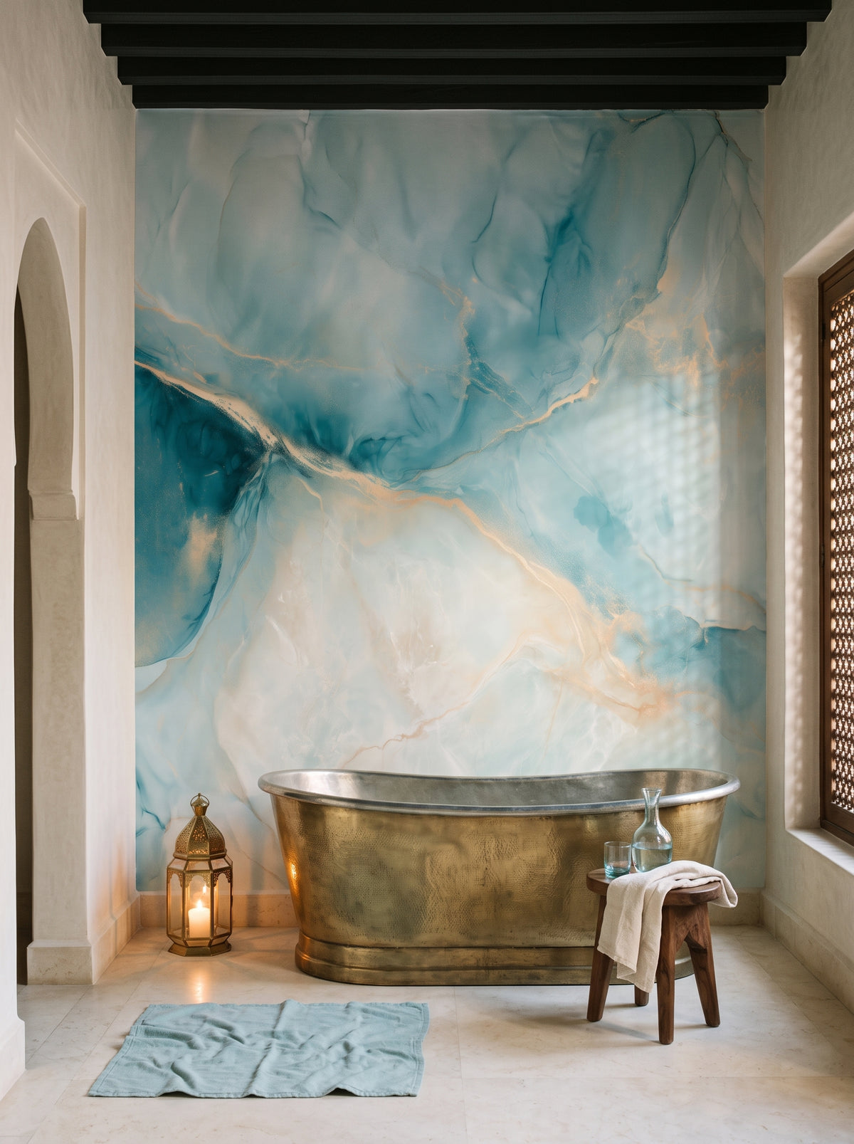 ONYX ESTUARY, mise en scène d’une salle de bain : papier peint effet onyx turquoise à veine dorée derrière une baignoire îlot en laiton
