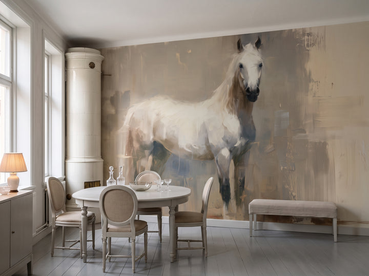 PALE VIGIL en una ambientación de comedor: toda la pared tras una mesa redonda clara y sillas en lino beige, junto a una estufa de azulejos blanca