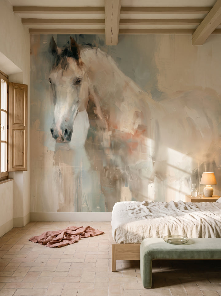 TENDER GLANCE en la ambientación de un dormitorio: caballo blanco sobre fondo pastel junto a una cama baja con ropa de lino y un banco salvia