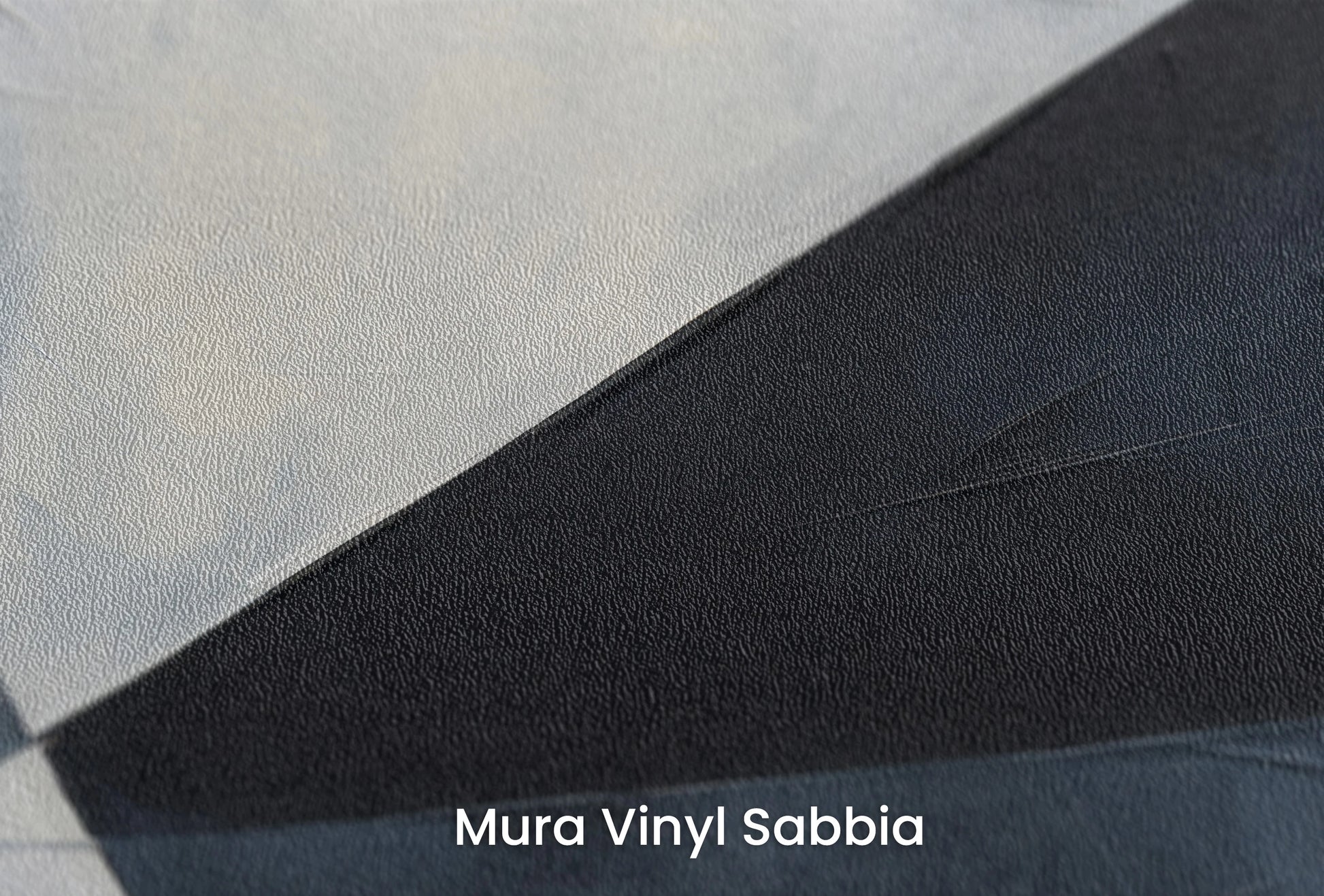 Zbliżenie na artystyczną fototapetę o nazwie Sharp Geometric Contrast na podłożu Mura Vinyl Sabbia struktura grubego ziarna piasku.