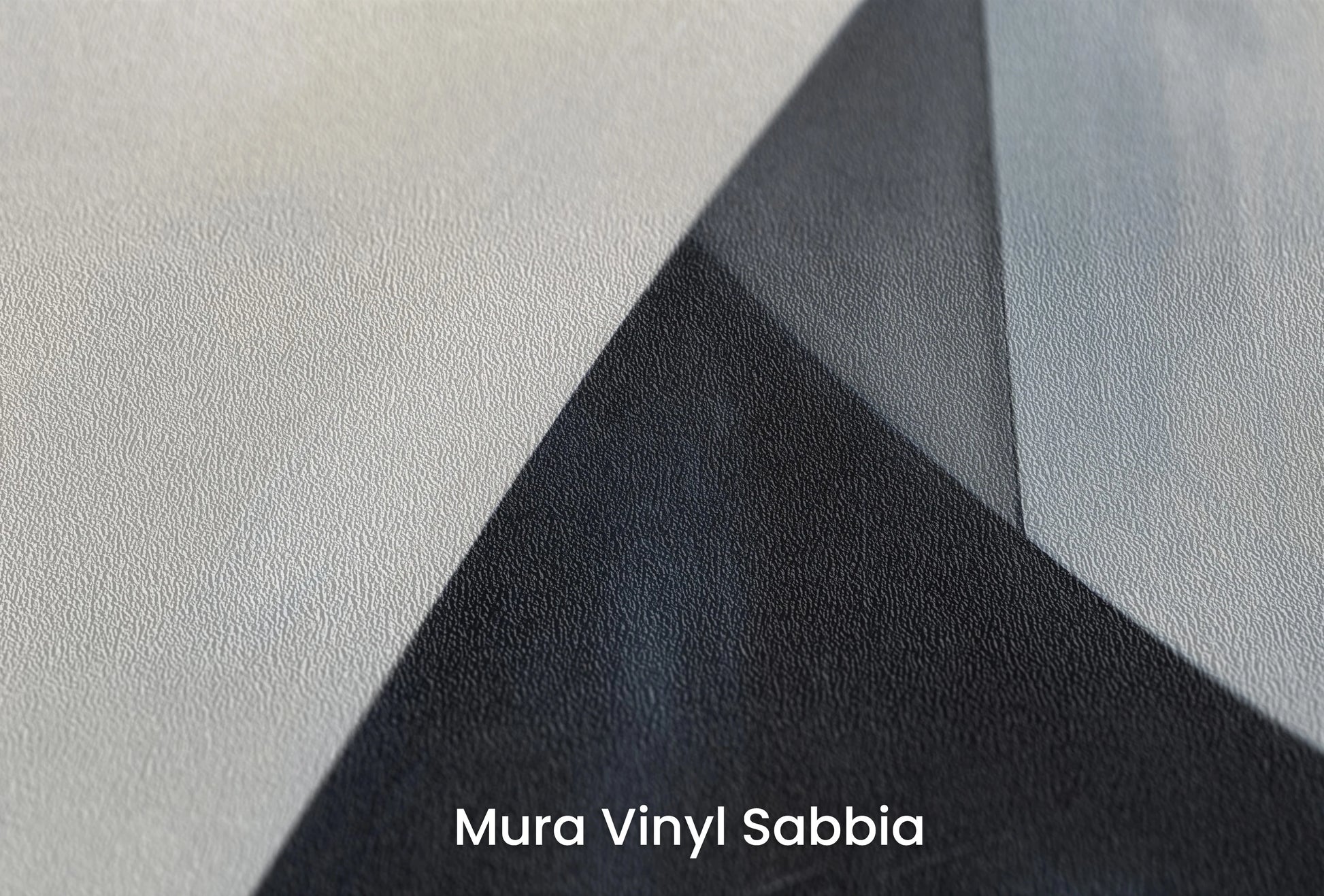 Zbliżenie na artystyczną fototapetę o nazwie Monochrome Triangle na podłożu Mura Vinyl Sabbia struktura grubego ziarna piasku.